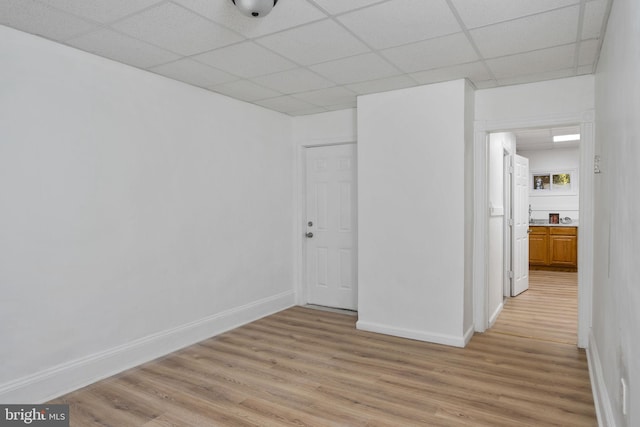 unfurnished room featuring light hardwood / wood-style flooring and a drop ceiling