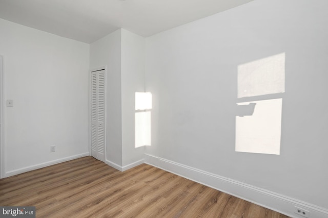 interior space featuring hardwood / wood-style flooring, multiple windows, and a closet