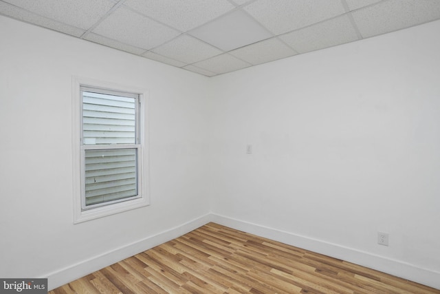 empty room featuring light hardwood / wood-style floors and a paneled ceiling