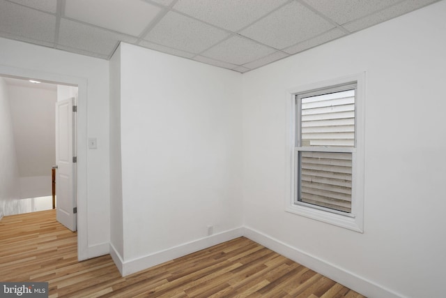 empty room with a paneled ceiling and hardwood / wood-style flooring