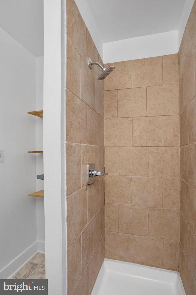 bathroom featuring built in shelves and a tile shower