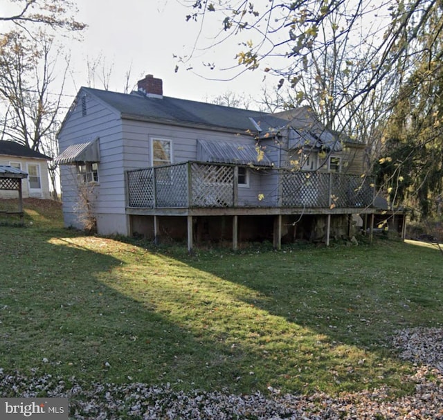 back of property with a lawn and a wooden deck