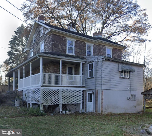 rear view of house featuring a lawn