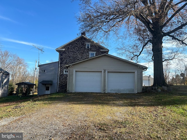 view of property exterior featuring a garage and a yard