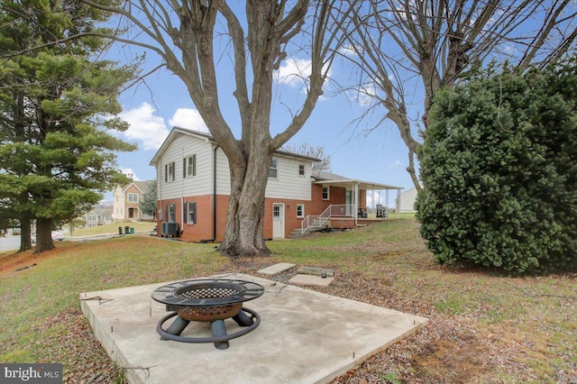 view of yard featuring a patio, central AC, and a fire pit