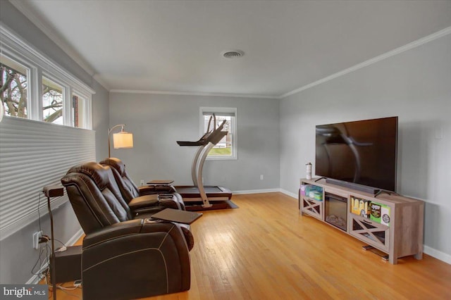 living room with ornamental molding, wood-type flooring, and a wealth of natural light