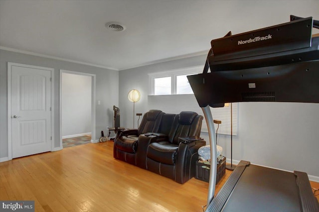 sitting room with hardwood / wood-style floors and crown molding