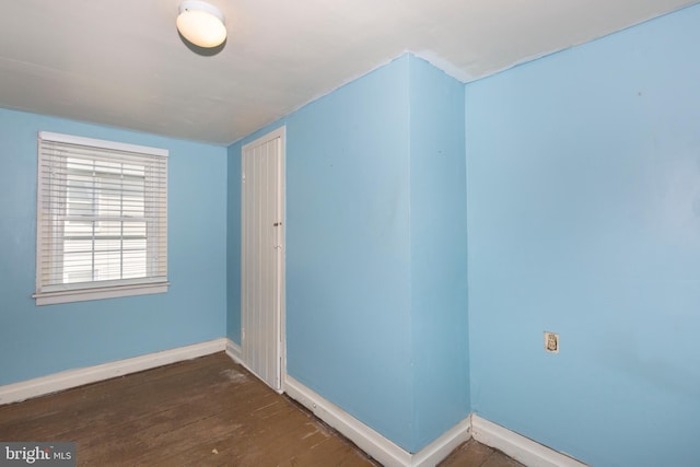 unfurnished room with dark wood-type flooring