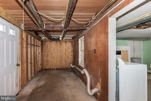 basement featuring washer / clothes dryer and wooden walls