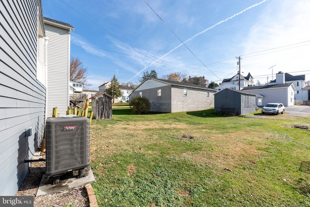 view of yard featuring central AC and a storage shed