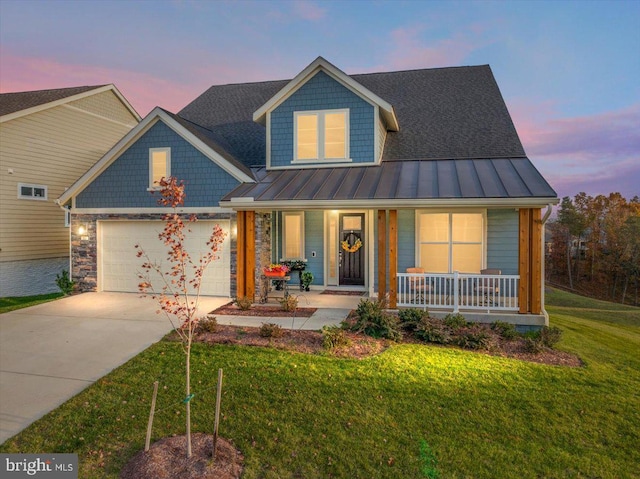 view of front of property with a porch, a garage, and a yard