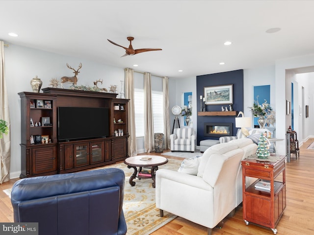 living room with ceiling fan and light wood-type flooring