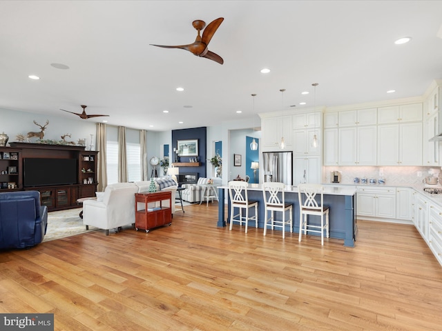 living room with ceiling fan and light hardwood / wood-style flooring