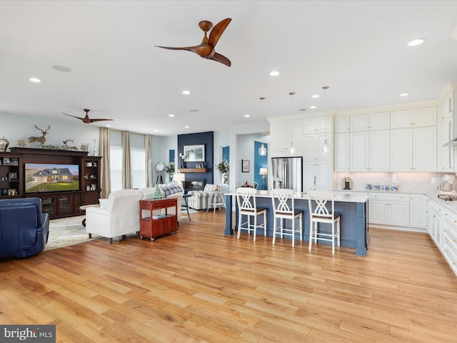 living room with ceiling fan and light wood-type flooring