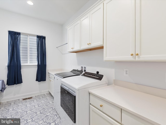 clothes washing area featuring cabinets and washing machine and dryer