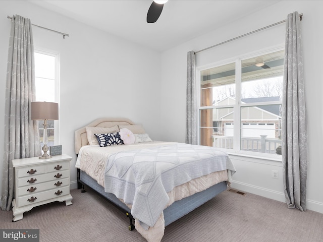 bedroom with carpet flooring, multiple windows, and ceiling fan