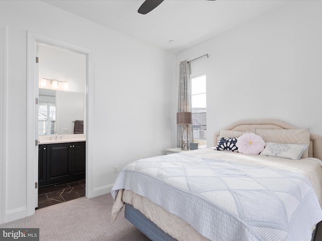 carpeted bedroom with sink, connected bathroom, multiple windows, and ceiling fan