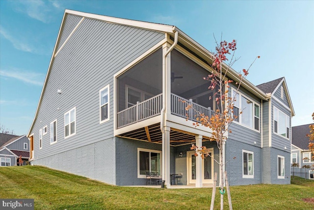 back of house with a lawn, a patio area, and a sunroom