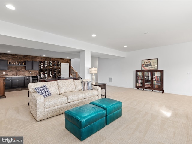 living room featuring wet bar and light carpet