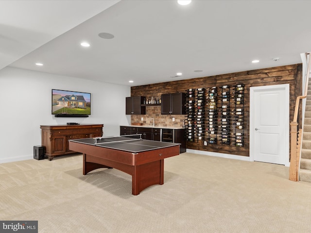 recreation room with light carpet and wet bar