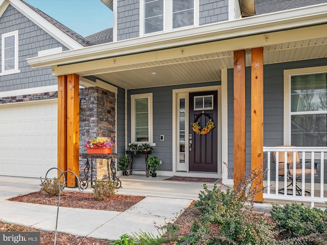 doorway to property featuring a porch and a garage