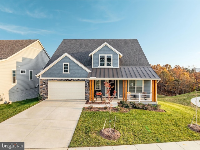 view of front of house featuring a front lawn, covered porch, and a garage