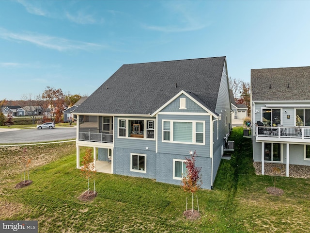 rear view of property featuring a yard and a sunroom