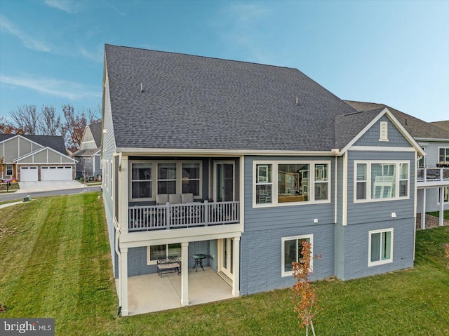 rear view of property featuring a lawn and a patio area