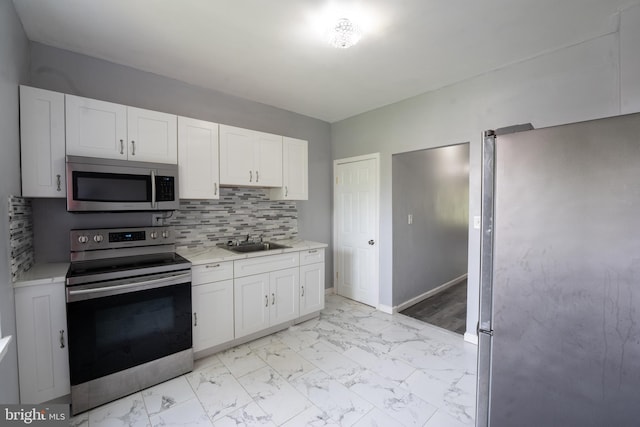 kitchen with white cabinetry, sink, appliances with stainless steel finishes, and tasteful backsplash