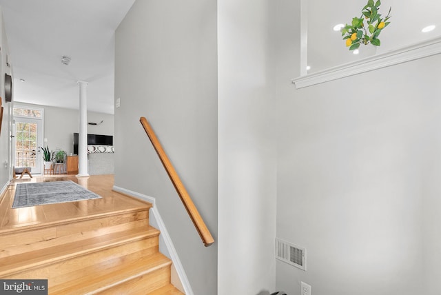 stairway featuring decorative columns and hardwood / wood-style flooring