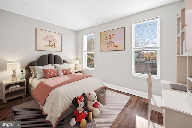 bedroom with dark hardwood / wood-style flooring and multiple windows