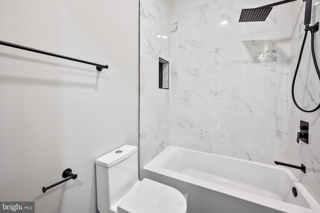 bathroom with toilet and tiled shower / bath