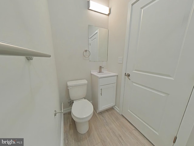 bathroom featuring toilet, vanity, and hardwood / wood-style flooring