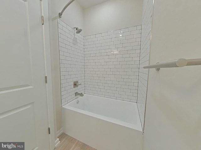 bathroom with wood-type flooring and tiled shower / bath