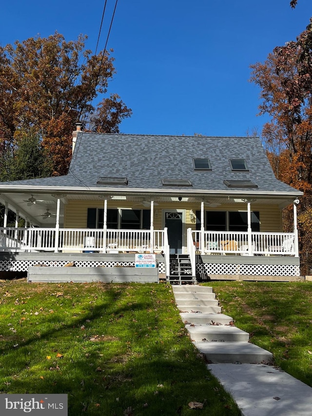 farmhouse-style home featuring ceiling fan, a front lawn, and a porch