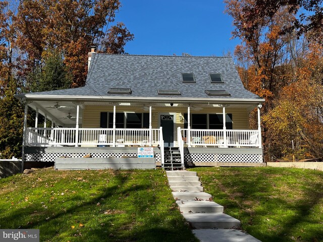 farmhouse-style home featuring covered porch and a front yard