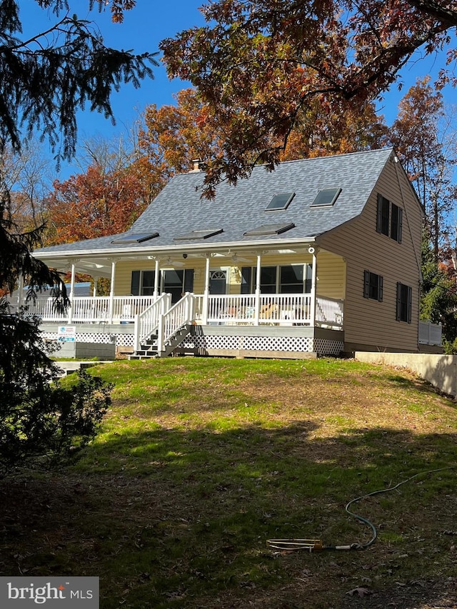 view of front of home with a wooden deck and a front lawn