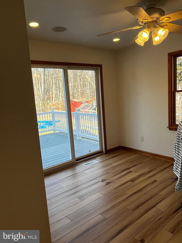 spare room with ceiling fan and light wood-type flooring