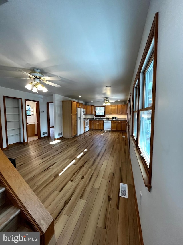 unfurnished living room with ceiling fan and light wood-type flooring