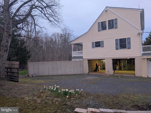view of property exterior with fence and gravel driveway
