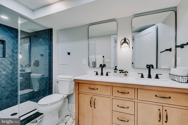 bathroom with toilet, double vanity, and a shower stall