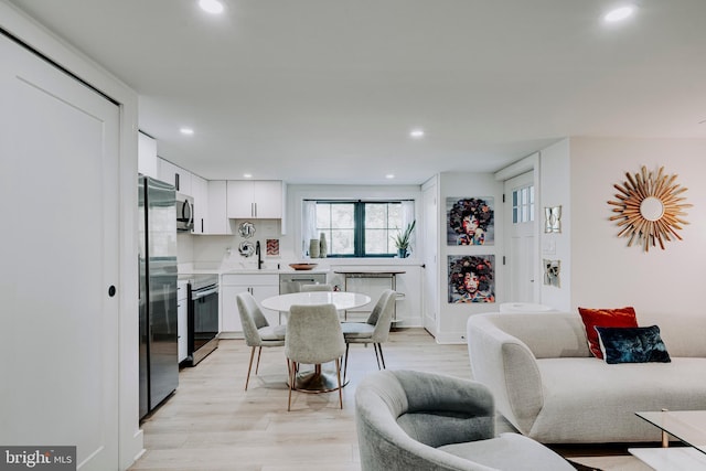 dining room with recessed lighting and light wood-style flooring