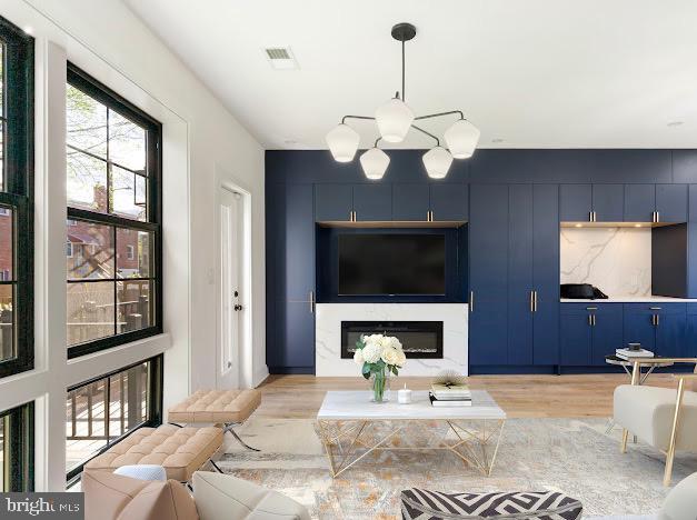 living room with light wood finished floors and a glass covered fireplace