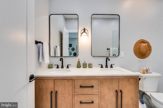 bathroom with toilet and double vanity