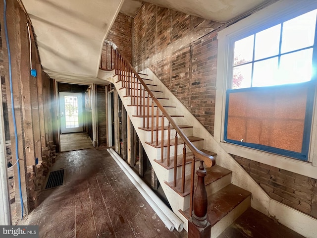 stairs with a wealth of natural light and wood-type flooring