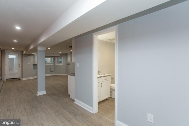 basement with light hardwood / wood-style flooring