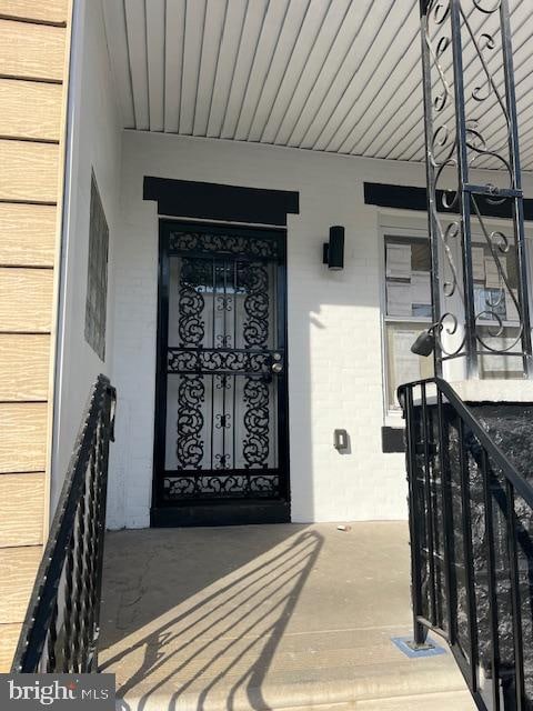 entrance to property featuring brick siding