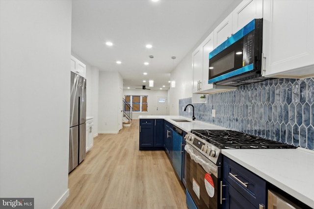 kitchen with white cabinets, blue cabinets, sink, light hardwood / wood-style floors, and stainless steel appliances