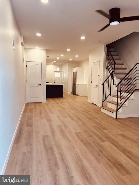 unfurnished living room with recessed lighting, a ceiling fan, baseboards, light wood-style floors, and stairway