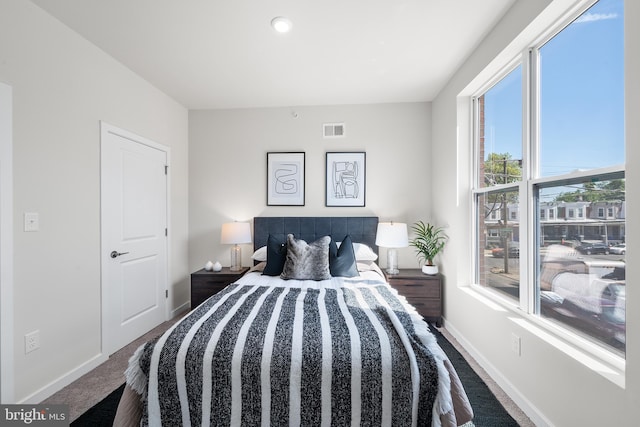 carpeted bedroom featuring multiple windows